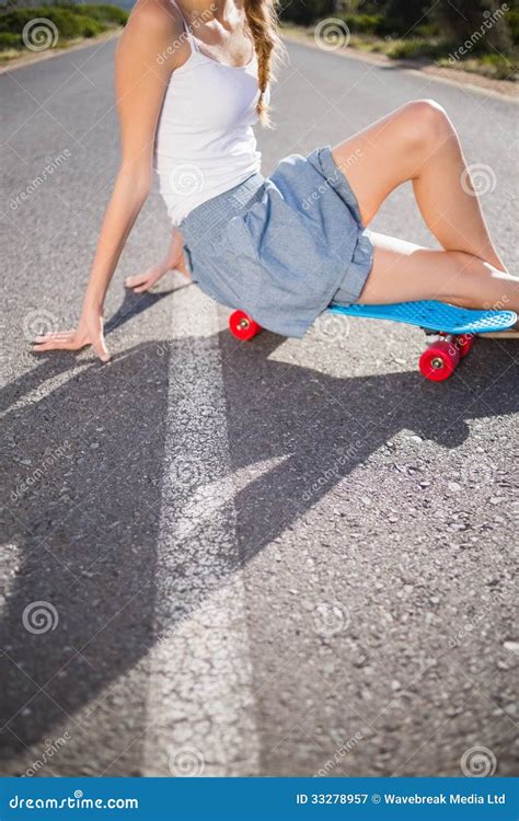 A Woman Sitting On The Steps With Her Skateboard