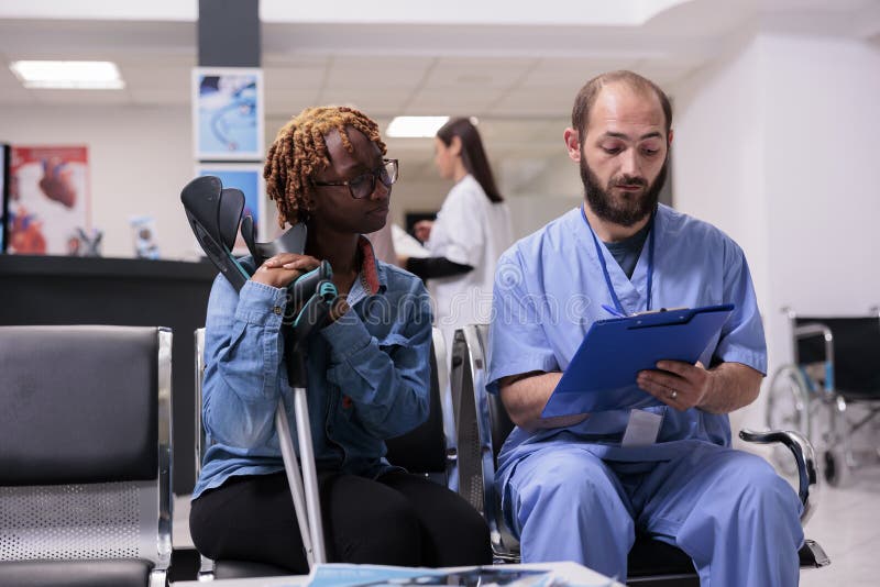 African American Woman On Crutches Listening Attentively Therapist