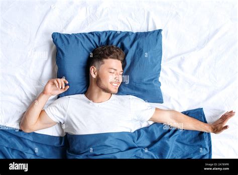 Bedtime Guy Lying On Bed Top View Waking Up Stretching Closed Eyes