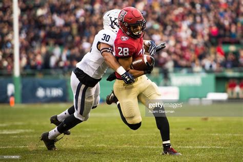 Henry Taylor Of The Harvard Crimson Scores A Touchdown While Being