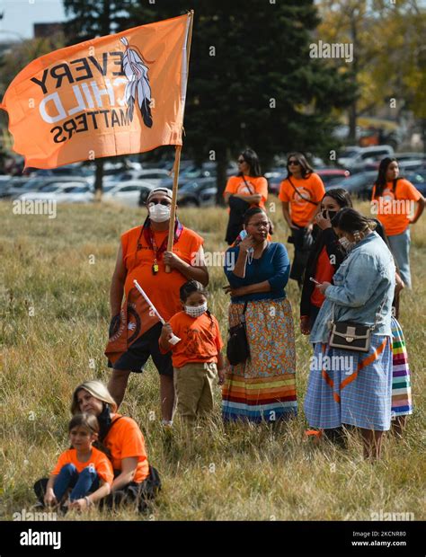 People Wearing Orange Shorts Attending An Outdoor Official Ceremony At