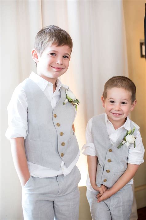 Two Ring Bearers Smiling In White Rolled Up Sleeves And Grey Vests And