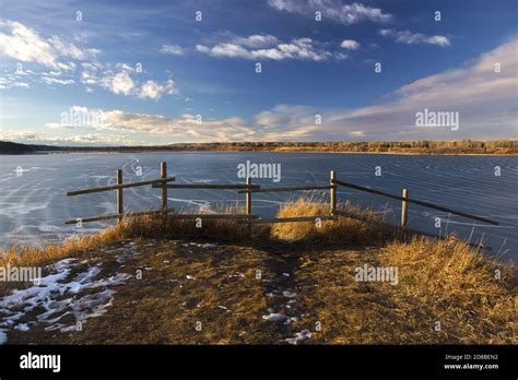 Wood Fence And Prairie Grass With Glenmore Reservoir Landscape Skyline